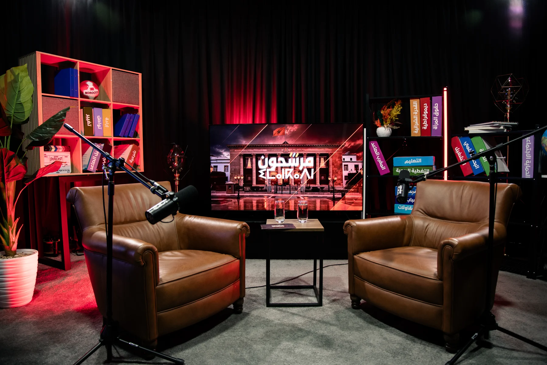 Décor feutré du studio Awal, fauteuils en cuir et bibliothèque éclairée